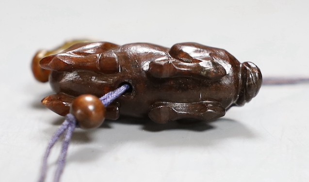 A Chinese green and brown jade ‘horse’ toggle. 4.5cm